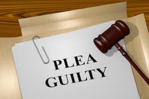 Plea guilty document with judge gavel on legal paperwork representing plea bargaining in criminal court